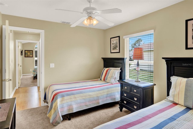 737 Oxford Dr, Davenport, FL 33897 - carpeted bedroom featuring a ceiling fan, wood finished floors, and baseboards