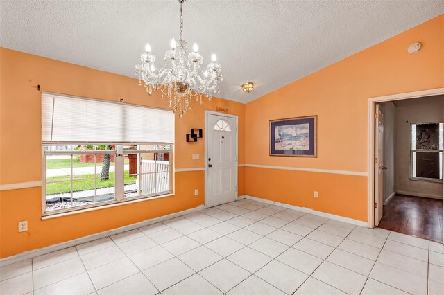 600 Regency Way, Kissimmee, FL 34758 - spare room featuring vaulted ceiling, a textured ceiling, a chandelier, a smoke detector, and tile patterned floors
