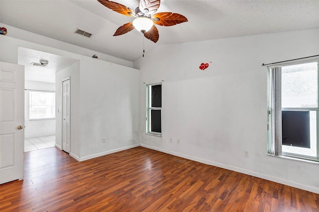 600 Regency Way, Kissimmee, FL 34758 - spare room featuring wood finished floors, ceiling fan, vaulted ceiling, and a textured ceiling