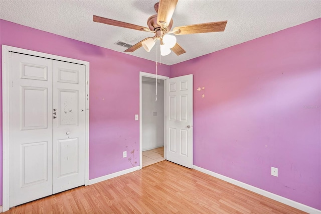 600 Regency Way, Kissimmee, FL 34758 - unfurnished bedroom with a textured ceiling, light wood-style floors, a closet, and ceiling fan
