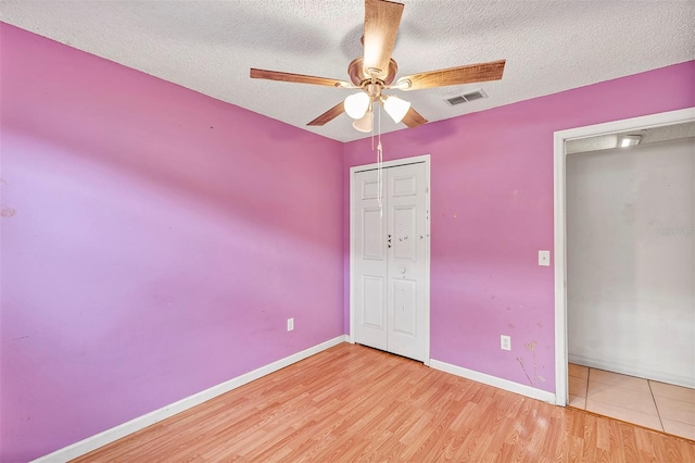 600 Regency Way, Kissimmee, FL 34758 - unfurnished bedroom featuring a textured ceiling, a closet, light wood-type flooring, and a ceiling fan