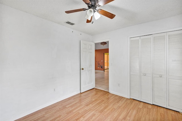 600 Regency Way, Kissimmee, FL 34758 - unfurnished bedroom with a textured ceiling, light wood-style flooring, a closet, and ceiling fan