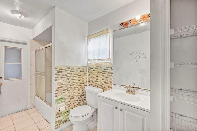 600 Regency Way, Kissimmee, FL 34758 - bathroom with tile walls, vanity, tile patterned floors, shower / bath combination with glass door, and wainscoting