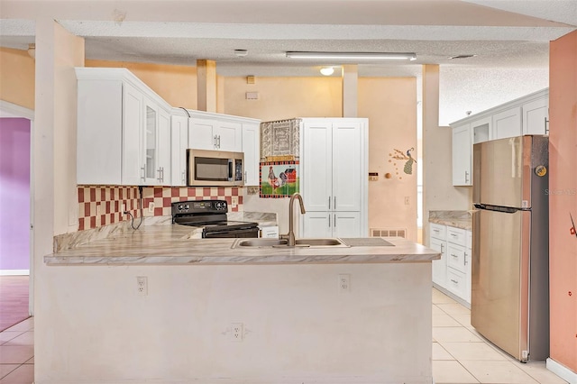 600 Regency Way, Kissimmee, FL 34758 - kitchen with stainless steel appliances, light tile patterned floors, a peninsula, and backsplash