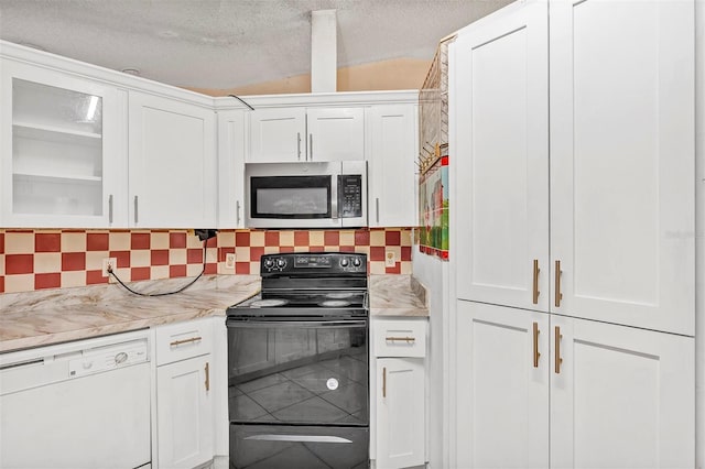 600 Regency Way, Kissimmee, FL 34758 - kitchen with stainless steel microwave, dishwasher, black electric range, white cabinetry, and a textured ceiling