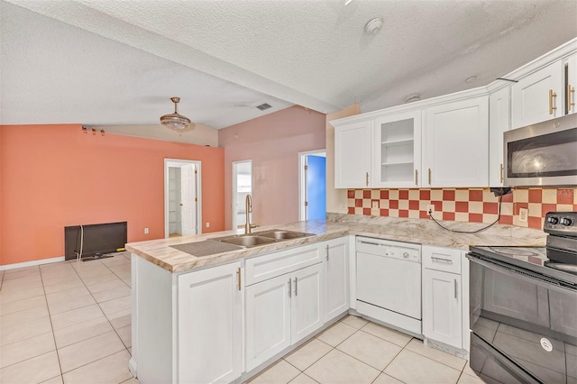 600 Regency Way, Kissimmee, FL 34758 - kitchen with white dishwasher, black electric range, stainless steel microwave, vaulted ceiling, and light tile patterned floors