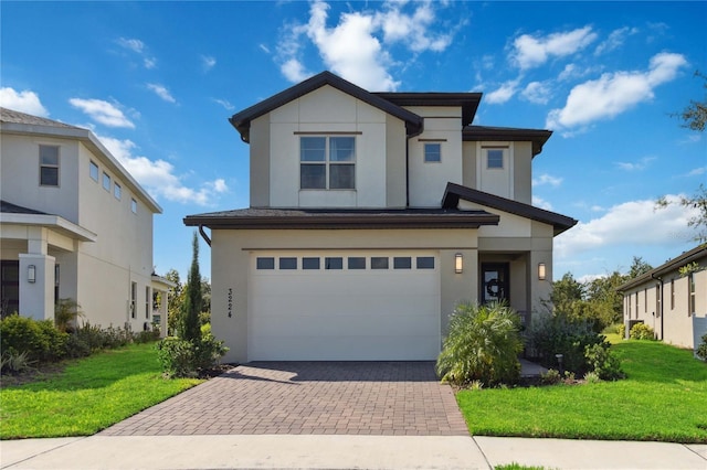 3224 Oxbow Ct, Harmony, FL 34773 - view of front facade with stucco siding, a front lawn, a garage, and decorative driveway