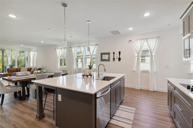3224 Oxbow Ct, Harmony, FL 34773 - kitchen with stainless steel dishwasher, a sink, dark wood finished floors, light countertops, and plenty of natural light