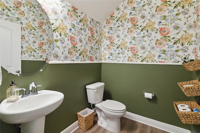 3224 Oxbow Ct, Harmony, FL 34773 - half bathroom featuring wood finished floors, baseboards, toilet, vaulted ceiling, and wallpapered walls