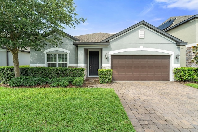 3424 Middlebrook Pl, Harmony, FL 34773 - single story home featuring stucco siding, a garage, decorative driveway, a front lawn, and stone siding