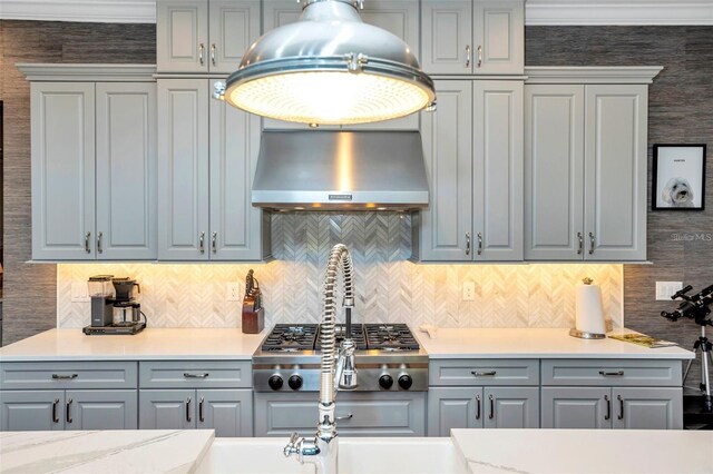 10836 Royal Cypress Way, Orlando, FL 32836 - kitchen with extractor fan, gray cabinetry, backsplash, and stainless steel gas cooktop
