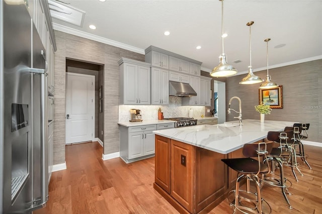 10836 Royal Cypress Way, Orlando, FL 32836 - kitchen with stainless steel fridge with ice dispenser, under cabinet range hood, ornamental molding, baseboards, and a kitchen bar