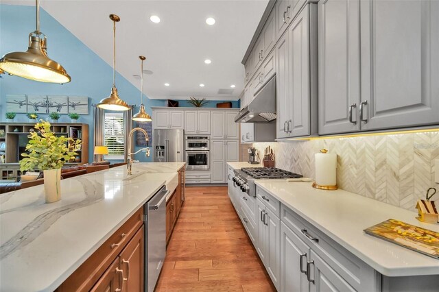 10836 Royal Cypress Way, Orlando, FL 32836 - kitchen with stainless steel appliances, under cabinet range hood, light wood-style floors, backsplash, and recessed lighting
