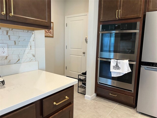 1896 Basenji Dr, Lake Alfred, FL 33850 - kitchen with appliances with stainless steel finishes, dark brown cabinetry, light countertops, and light tile patterned floors