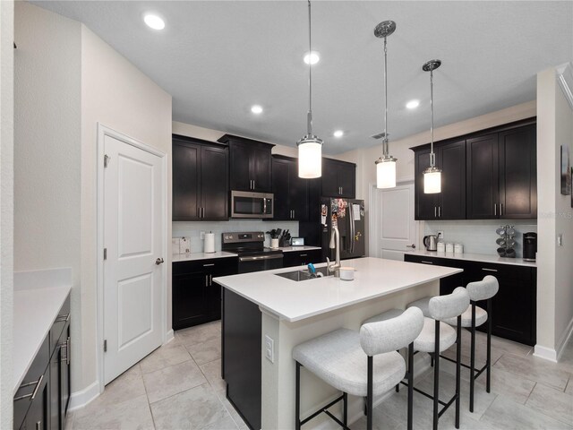 3052 Prelude Ln, Kissimmee, FL 34746 - kitchen with stainless steel microwave, range with electric cooktop, a sink, a breakfast bar area, and a center island with sink