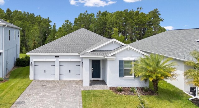 3052 Prelude Ln, Kissimmee, FL 34746 - ranch-style house featuring a shingled roof, stucco siding, an attached garage, and a front lawn