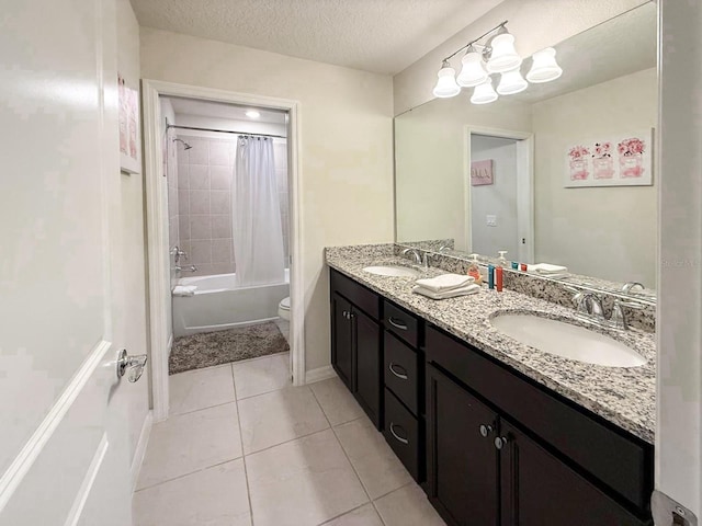 1876 Summer Dr, Davenport, FL 33897 - full bathroom featuring toilet, double vanity, tile patterned flooring, shower / bath combo with shower curtain, and a textured ceiling