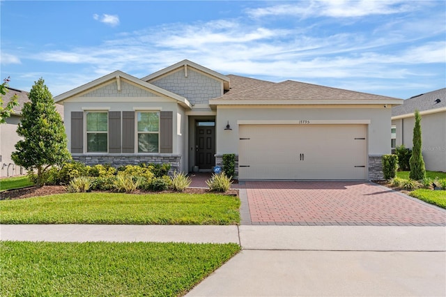 17795 Blazing Star Cir, Clermont, FL 34714 - ranch-style house with stone siding, decorative driveway, a garage, a front yard, and stucco siding