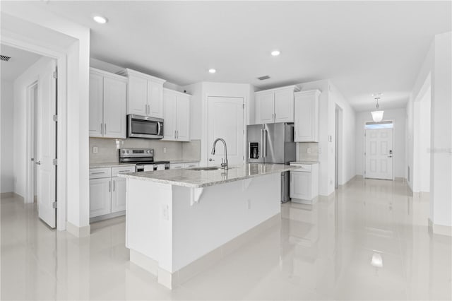17795 Blazing Star Cir, Clermont, FL 34714 - kitchen with stainless steel appliances, a sink, recessed lighting, white cabinets, and baseboards