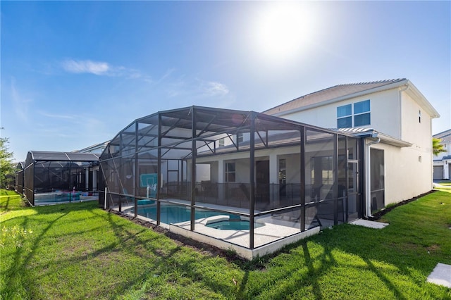 2623 Calistoga Ave, Kissimmee, FL 34741 - rear view of house with a yard, a lanai, stucco siding, a pool with connected hot tub, and a patio area