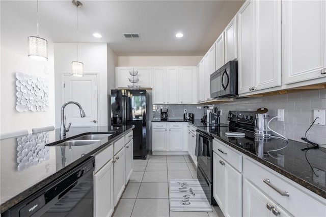 2623 Calistoga Ave, Kissimmee, FL 34741 - kitchen featuring black appliances, a sink, tasteful backsplash, white cabinetry, and dark stone countertops