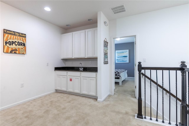 2623 Calistoga Ave, Kissimmee, FL 34741 - kitchen featuring light colored carpet, dark countertops, baseboards, white cabinetry, and recessed lighting