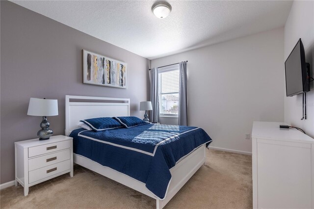 2623 Calistoga Ave, Kissimmee, FL 34741 - bedroom with light carpet, a textured ceiling, and baseboards