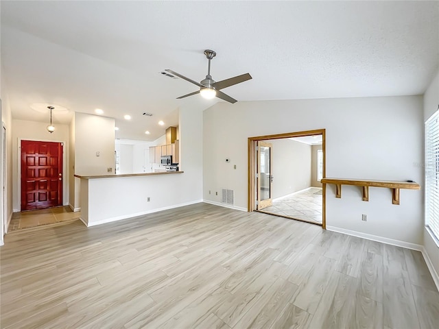 5452 Higgins Way, Orlando, FL 32808 - unfurnished living room with ceiling fan, light wood-type flooring, vaulted ceiling, and baseboards