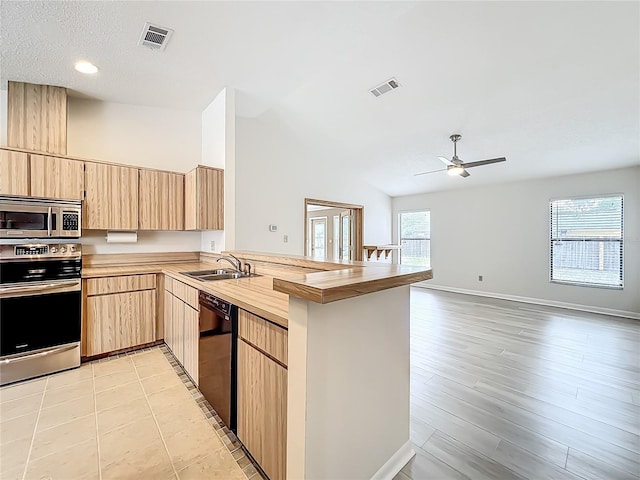 5452 Higgins Way, Orlando, FL 32808 - kitchen with stainless steel microwave, a sink, light brown cabinets, dishwasher, and recessed lighting