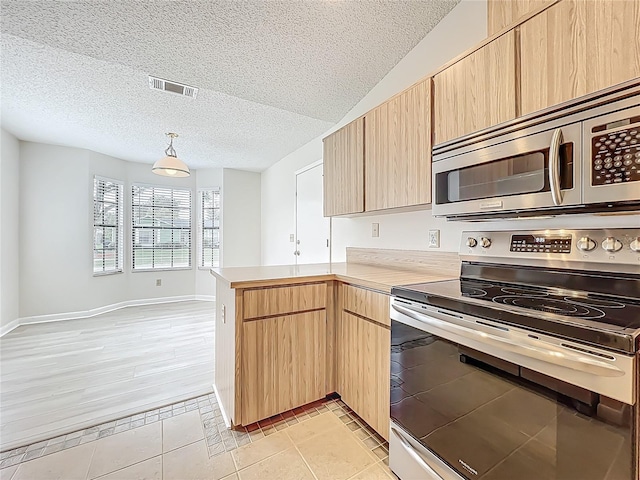5452 Higgins Way, Orlando, FL 32808 - kitchen featuring appliances with stainless steel finishes, light brown cabinetry, a peninsula, light countertops, and a textured ceiling