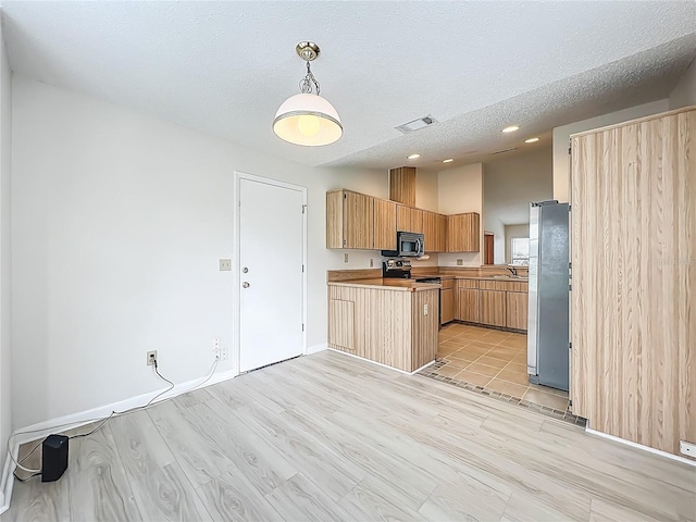 5452 Higgins Way, Orlando, FL 32808 - kitchen with stainless steel appliances, a sink, a peninsula, a textured ceiling, and baseboards