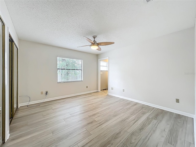 5452 Higgins Way, Orlando, FL 32808 - unfurnished bedroom with light wood-style flooring, a textured ceiling, baseboards, and a ceiling fan