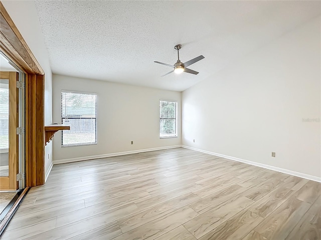 5452 Higgins Way, Orlando, FL 32808 - unfurnished room featuring light wood-type flooring, ceiling fan, baseboards, a textured ceiling, and lofted ceiling