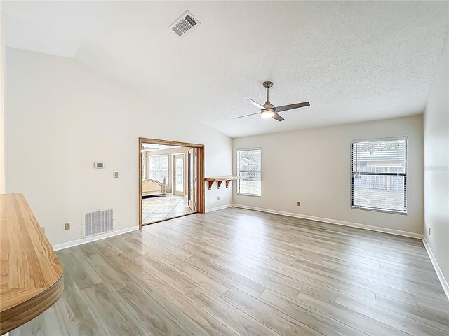 5452 Higgins Way, Orlando, FL 32808 - spare room with a ceiling fan, light wood finished floors, baseboards, a textured ceiling, and lofted ceiling