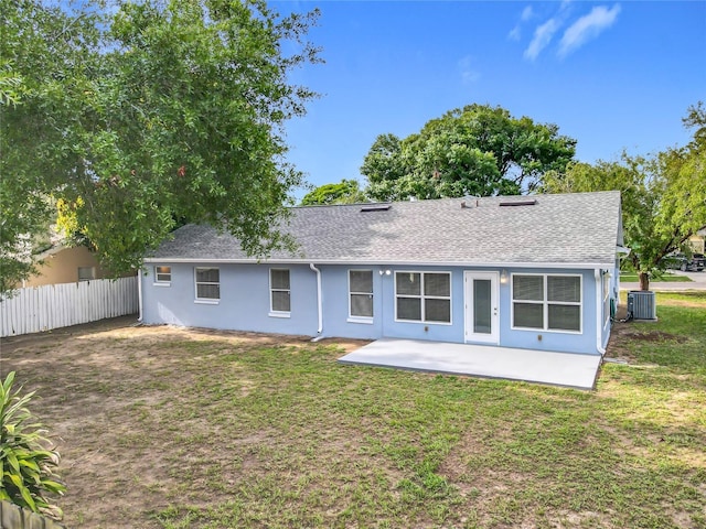 5452 Higgins Way, Orlando, FL 32808 - rear view of property featuring central AC unit, a shingled roof, stucco siding, and a patio area