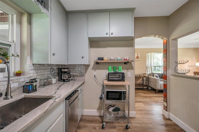 2601 Upton St S, Gulfport, FL 33711 - kitchen with a sink, stainless steel dishwasher, decorative backsplash, light wood-style flooring, and black microwave