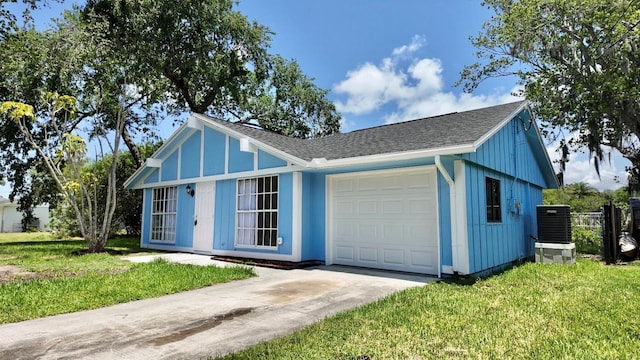 4546 Ontario Dr, New Port Richey, FL 34652 - view of front of home with central air condition unit, a garage, a front lawn, concrete driveway, and roof with shingles