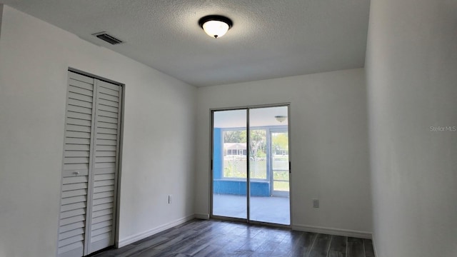 4546 Ontario Dr, New Port Richey, FL 34652 - unfurnished bedroom with dark wood-style floors, a textured ceiling, access to outside, and baseboards