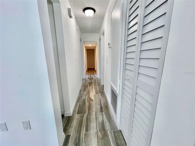 4546 Ontario Dr, New Port Richey, FL 34652 - corridor with dark wood-type flooring, baseboards, and a textured ceiling
