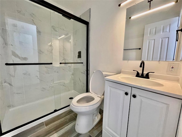 4546 Ontario Dr, New Port Richey, FL 34652 - bathroom with toilet, a shower stall, vanity, and wood finished floors