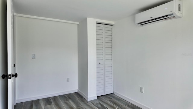 4546 Ontario Dr, New Port Richey, FL 34652 - unfurnished bedroom with a wall unit AC, dark wood-style flooring, baseboards, and a closet