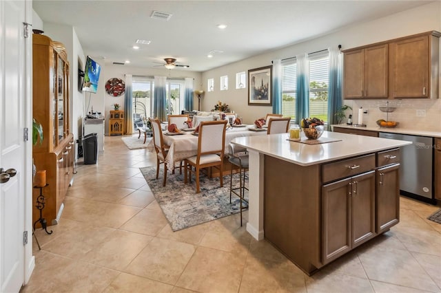 kitchen with dishwasher, light countertops, recessed lighting, a kitchen island, and decorative backsplash