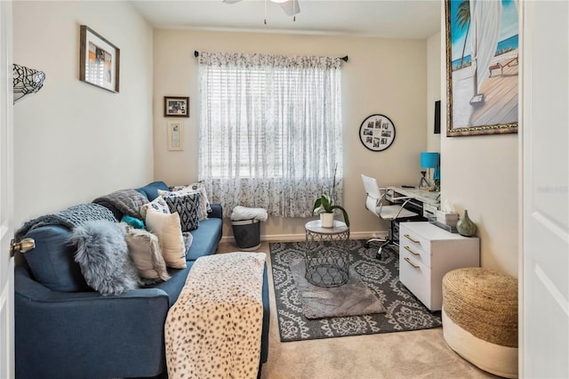 living area featuring ceiling fan and a desk