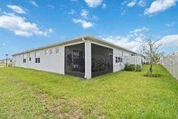 back of property featuring a lawn and a sunroom