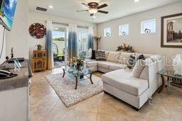 living room with plenty of natural light, a ceiling fan, recessed lighting, and light tile patterned floors