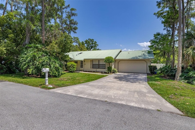 4307 Oak Ct, Saint Cloud, FL 34769 - ranch-style home featuring an attached garage, a front lawn, concrete driveway, and metal roof