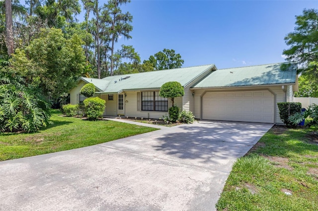 4307 Oak Ct, Saint Cloud, FL 34769 - single story home with driveway, a garage, a front yard, and metal roof