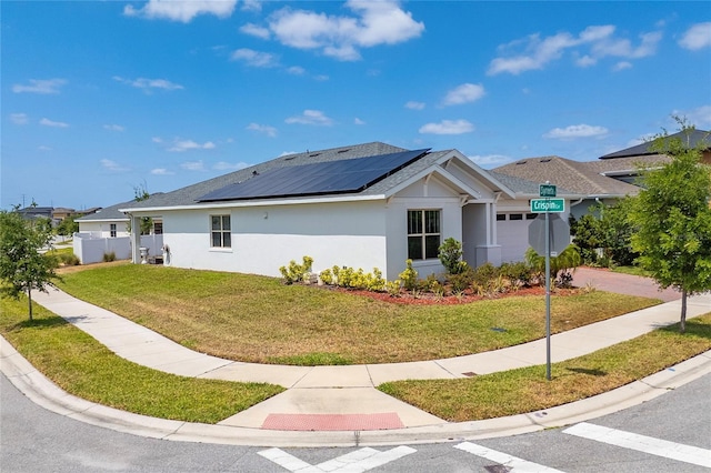 6651 Syreeta Ln, Harmony, FL 34773 - view of side of home featuring roof mounted solar panels, an attached garage, stucco siding, and a yard