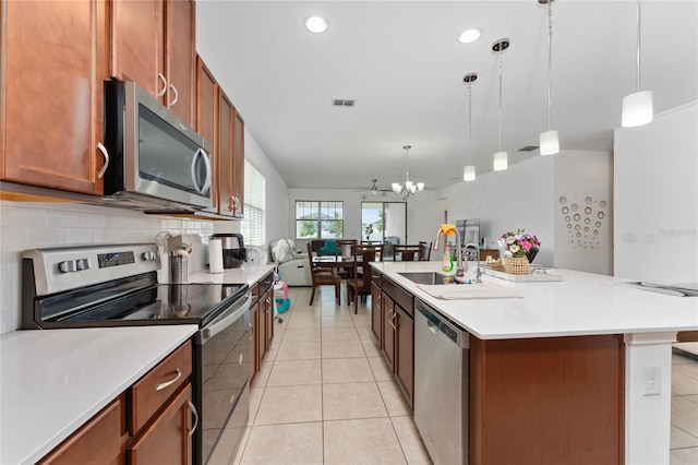 6651 Syreeta Ln, Harmony, FL 34773 - kitchen with stainless steel appliances, a chandelier, light tile patterned floors, light countertops, and recessed lighting