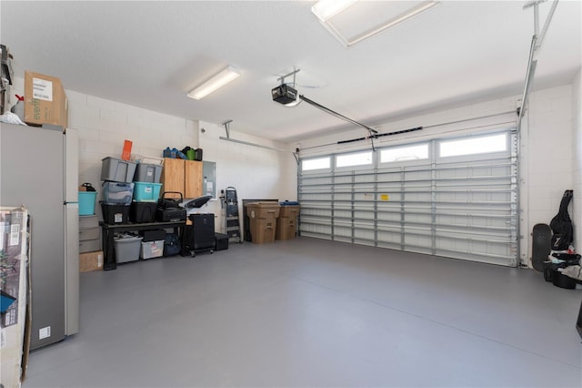 6651 Syreeta Ln, Harmony, FL 34773 - garage featuring electric panel, a garage door opener, concrete block wall, and freestanding refrigerator